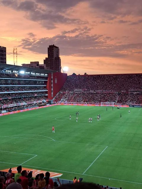 Football from the stands: a stadium at sunset, fireworks before kick-off, the players celebrating with the fans
